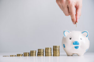 human hand inserting coin piggybank